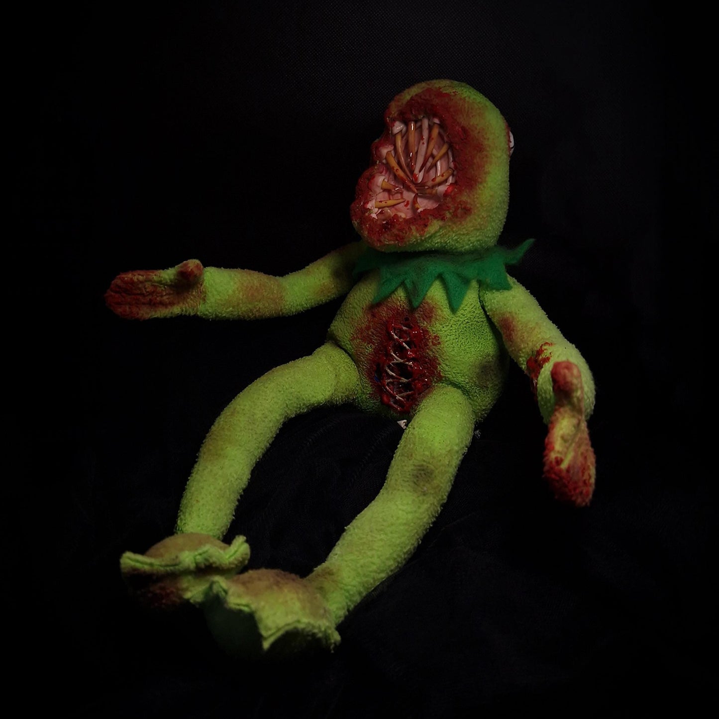 Kermit the frog with big mouth with sharp teeth and bloody open stomach with threads