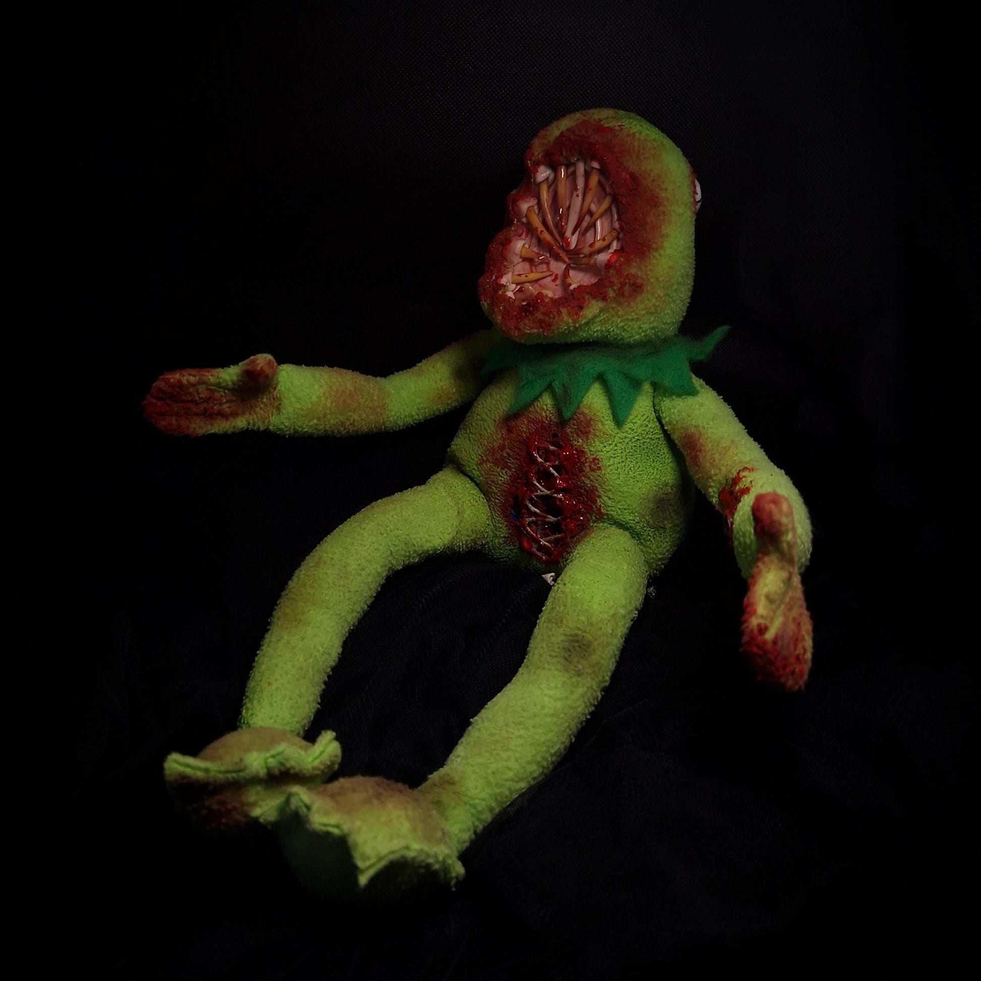 Kermit the frog with big mouth with sharp teeth and bloody open stomach with threads 