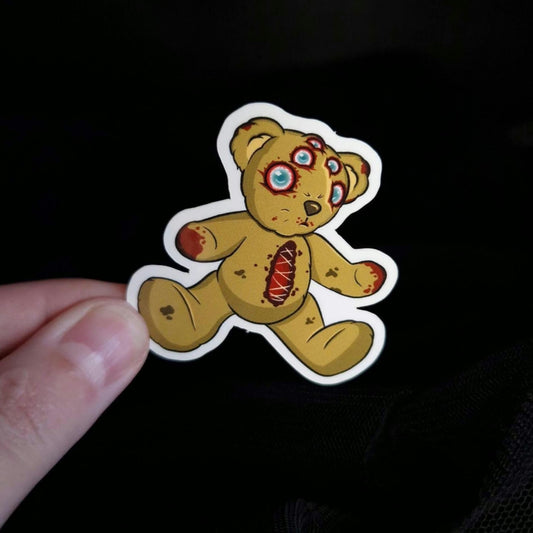 Teddy bear sticker with 5 blind eyes and open stomach